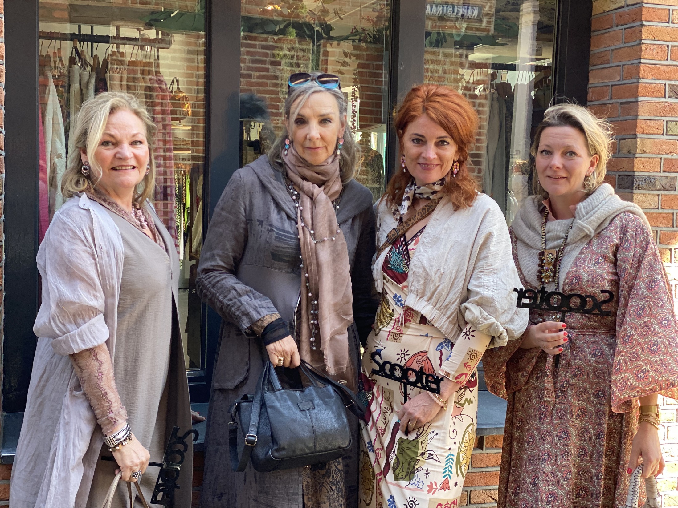 Vier dames bij Scooter, voor de etalage van de winkel