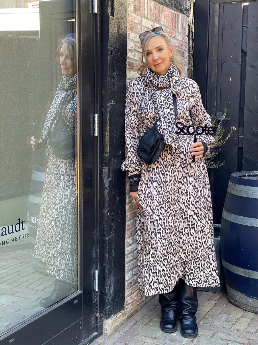 Scooter outfit met een lange jas met dierenprint en zwarte laarzen